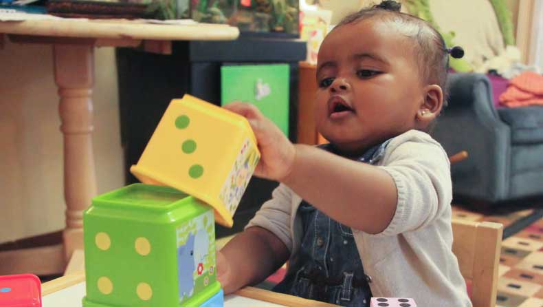 Toddler playing with stacking blocks.